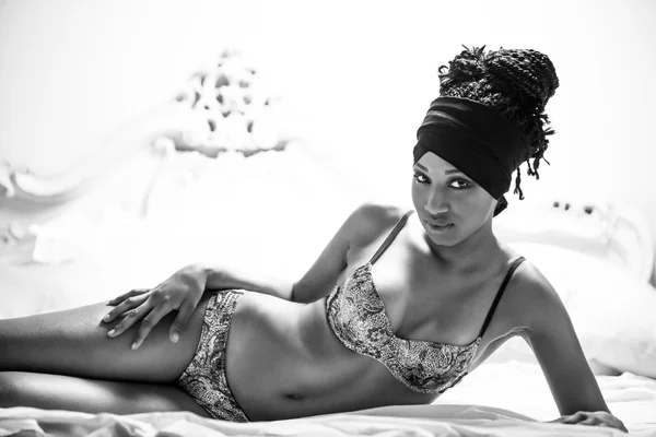 Modell liegt auf einem Bett und trägt Unterwäsche schwarz-weiß — Stockfoto