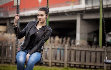 Bir salıncak üzerinde oturan ve arıyorum güzel kız