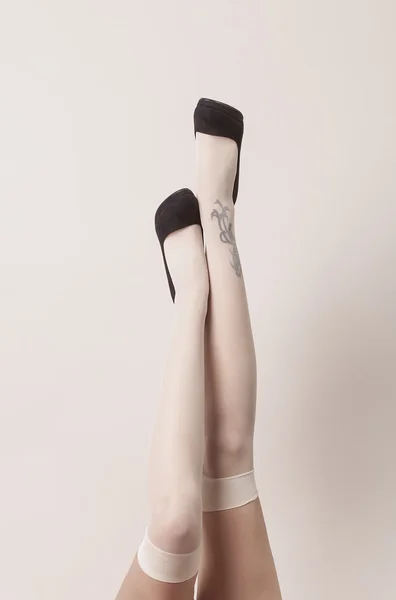 Жіночі ноги в сексуальному положенні в паризьких панчохах і каблуці Ліцензійні Стокові Зображення
