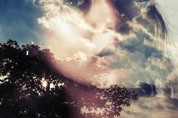 Double exposure of girl and tree silhouette with clouds