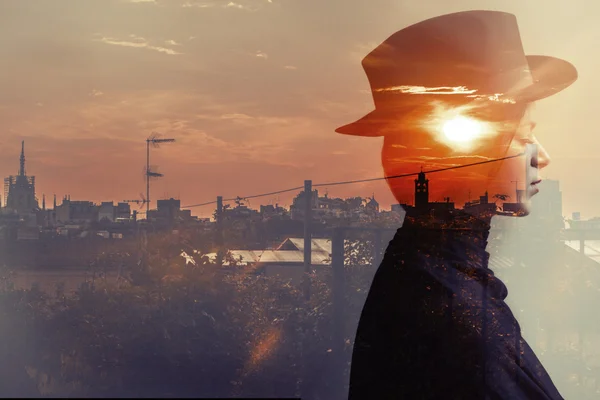 Doppia esposizione di ragazza che indossa cappello e tramonto della città — Foto Stock