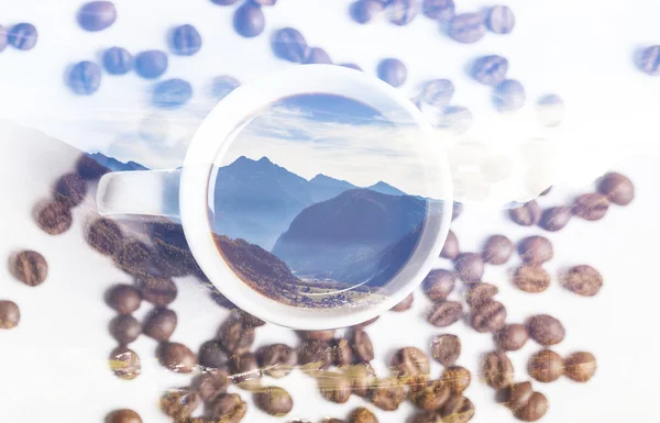 Double exposure of mountainscape and cup of coffee