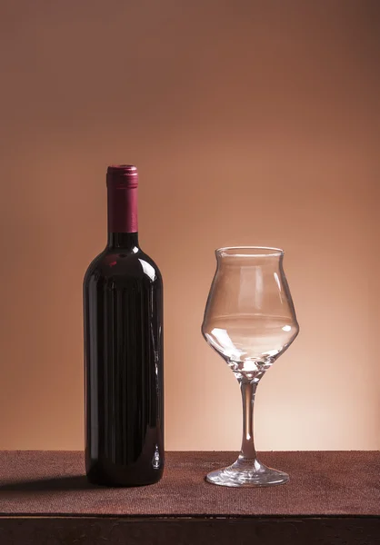 Red wine bottle and empty wineglass — Stock Photo, Image