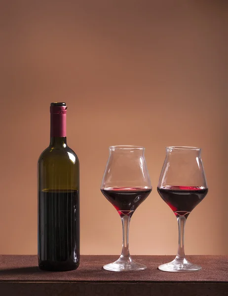 Bottiglia di vino rosso e due bicchieri riempiti — Foto Stock