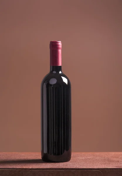 茶色の背景に赤ワインの瓶 — ストック写真