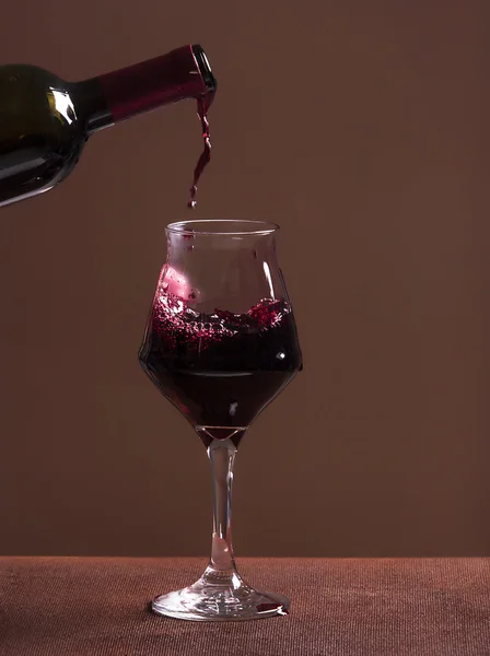 Rotweinflasche, gefülltes Weinglas und Weintropfen — Stockfoto
