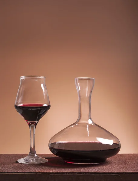Bicchiere di vino rosso e decanter pieno — Foto Stock