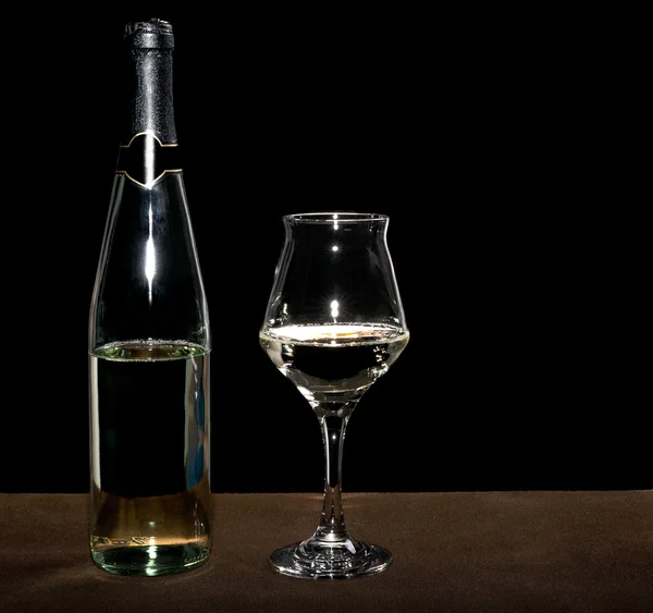 Láhev bílého vína a detailním naplněné sklenice na víno — Stock fotografie