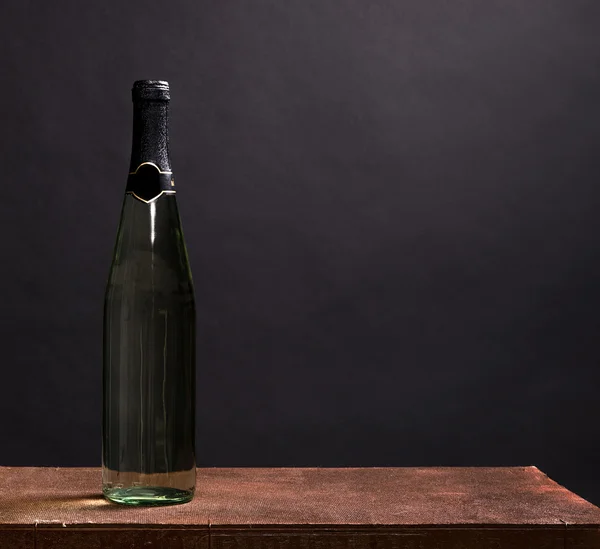 Bílé víno láhev na černém pozadí — Stock fotografie