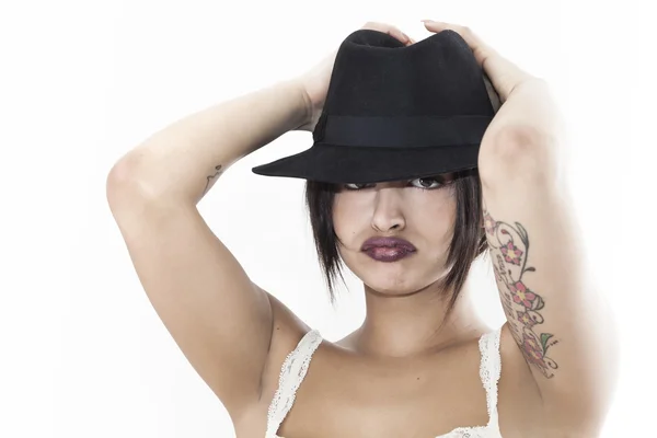 Hermosa mujer grouching y usando sombrero negro —  Fotos de Stock