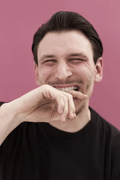 Retrato de homem engraçado mordendo a mão e sorrindo — Fotografia de Stock