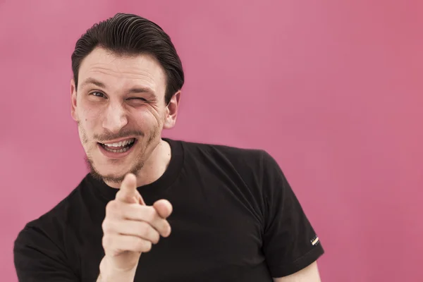 Bonito homem retrato sorrindo, piscando e apontando — Fotografia de Stock