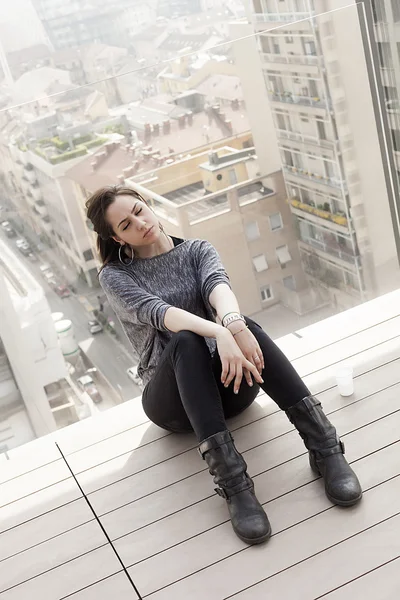 Beautiful girl sitting with closed eyes and cityscape — Stock Photo, Image