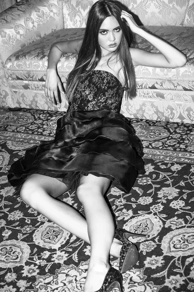 Дівчина лежить на килимі і в сукні чорно-біла — стокове фото