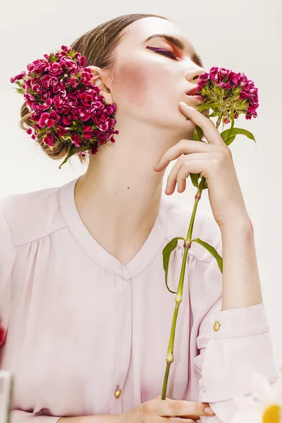 Vacker flicka stående bär och hålla blommor — Stockfoto