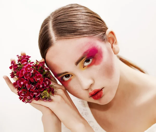 Söt flicka skönhet stående med röda blommor — Stockfoto