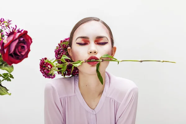 Mujer belleza retrato mordiendo rama de flor con los ojos cerrados — Foto de Stock