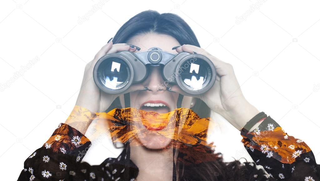 Double exposure of girl looking through binoculars and mountains