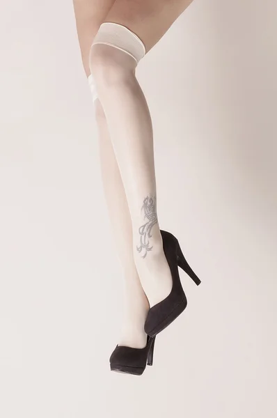 Pernas femininas em perfil de posição sexy usando meias e saltos — Fotografia de Stock