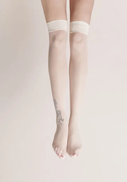 Pernas femininas usando meias parisienses — Fotografia de Stock