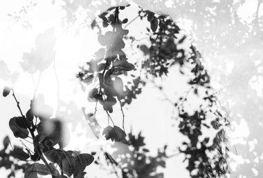 Double exposure of girl with gorgeous eyes and leaves