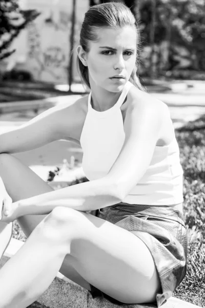 Woman portrait sitting on the sidewalk black and white — Stockfoto