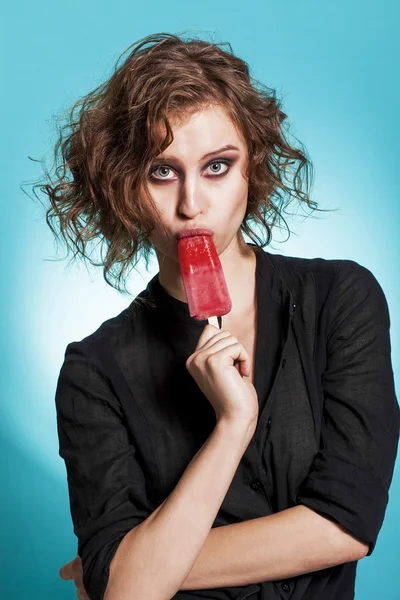 Beautiful girl portrait eating a strawberry popsicle and looking — 스톡 사진