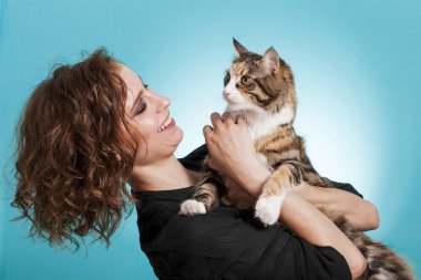 Güzel ve gülümseyerek kız holding kedi