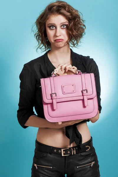 Mooi meisje portret bedrijf een roze zak met onzekere look — Stockfoto