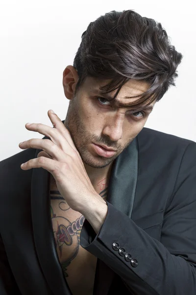 Bonito homem tatuado vestindo casaco preto e olhando — Fotografia de Stock