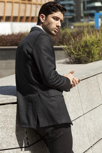 Bonito retrato de empresário olhando para trás e fundo da cidade — Fotografia de Stock