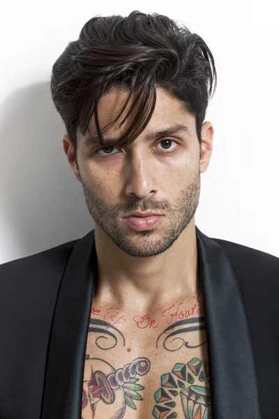 Татуированный человек крупным планом портрет в черной куртке и глядя — стоковое фото