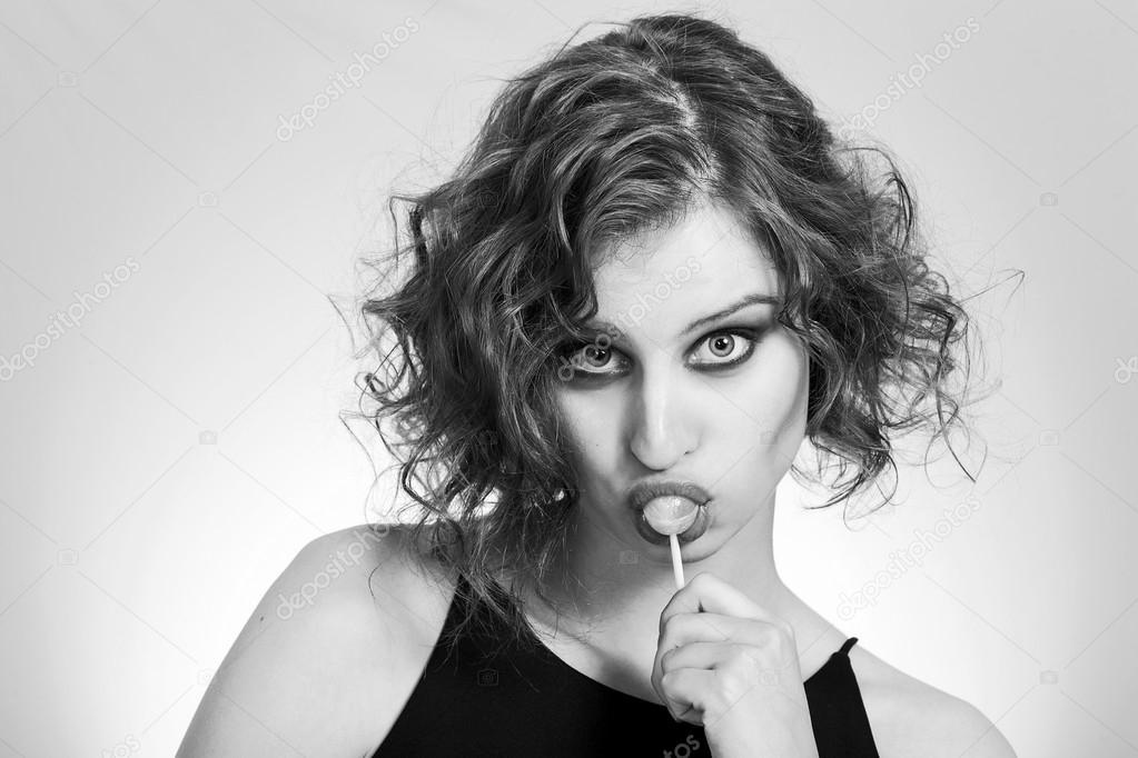 Beautiful girl closeup portrait sucking a lollipop black and whi