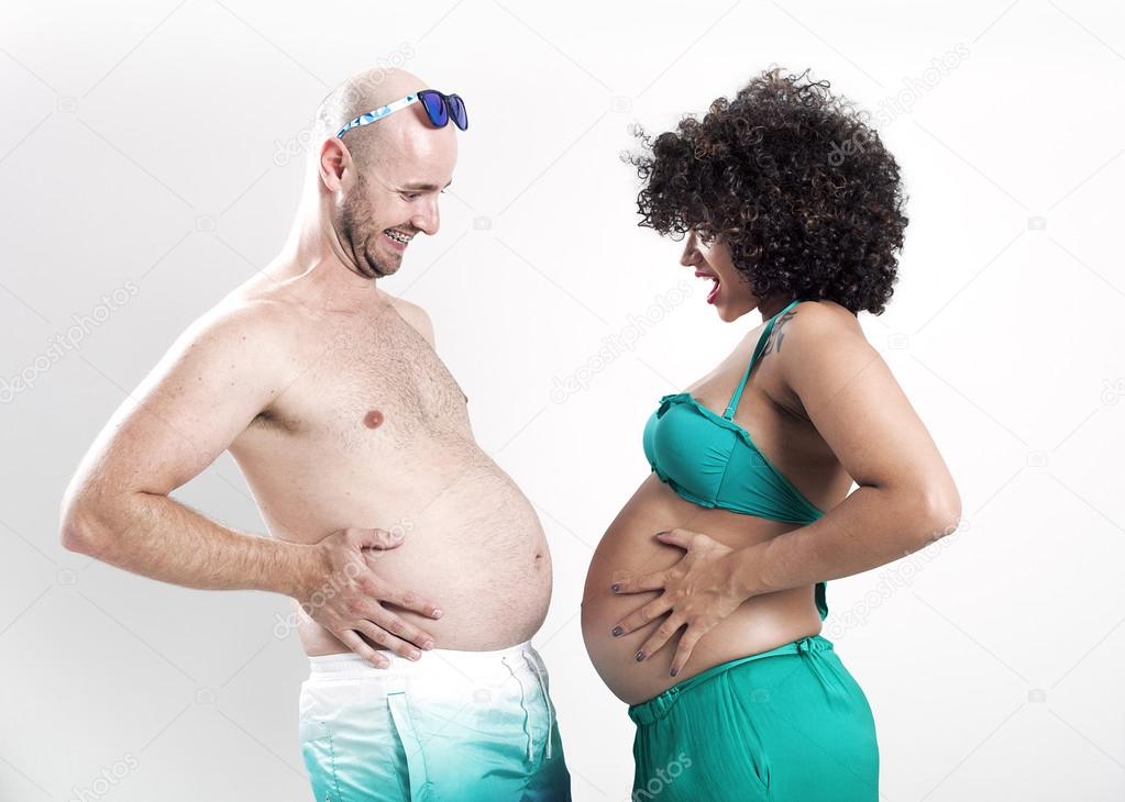 Beautiful and funny pregnant couple comparing bellies
