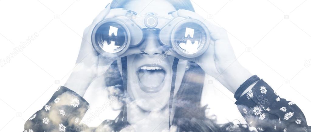 Double exposure of girl looking through binoculars and cloudscap