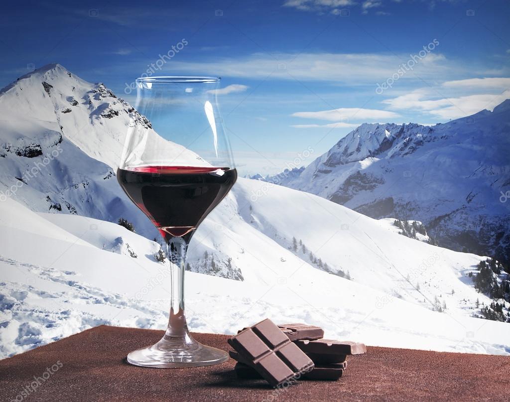 Wine glass and chocolate with winter mountainscape