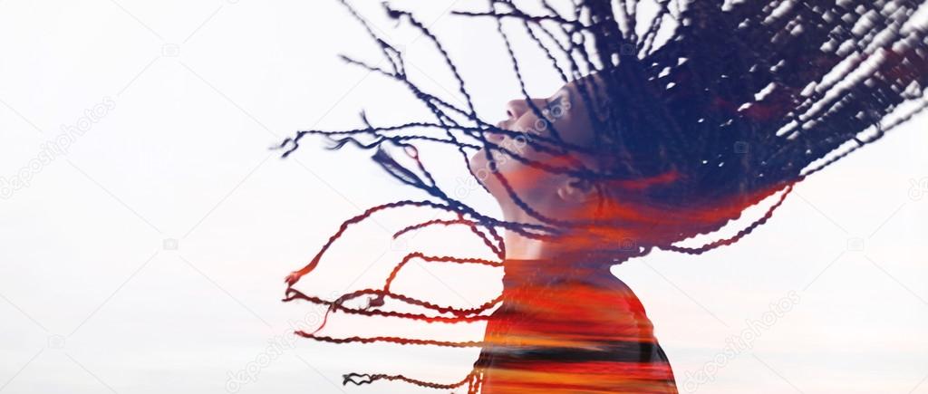 Double exposure of girl throwing braids and sunset letterbox
