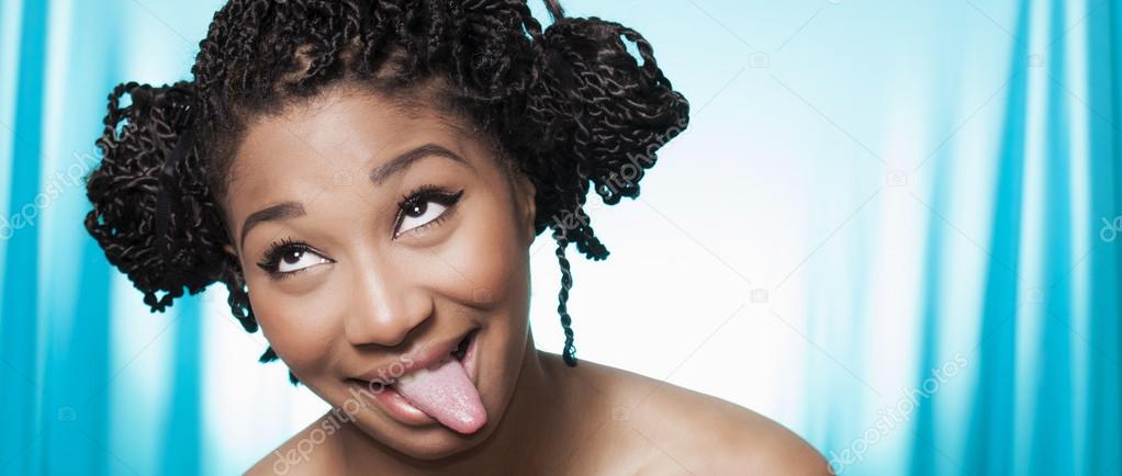 Beautiful smiling model with tongue stuck out looking aside lett