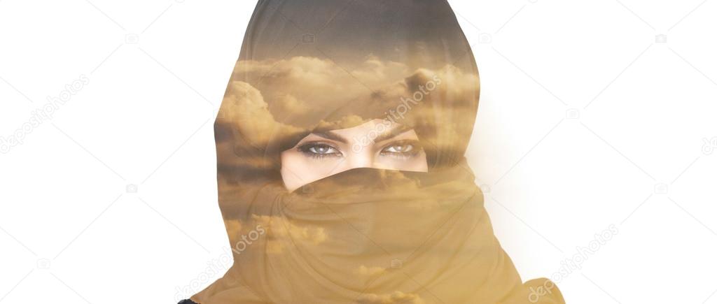Double exposure of woman wearing burqa and sunset clouds letterb