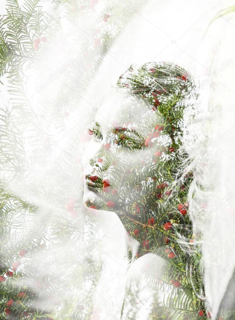 Double exposure of beautiful woman and pine needles with berries