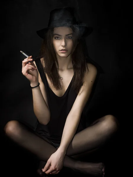 Krásná dívka portrét sezení a kouření cigaret — Stock fotografie