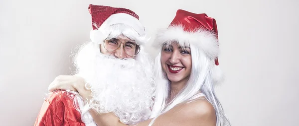 Feminino e masculino Papai Noel abraçando e sorrindo caixa de correio — Fotografia de Stock