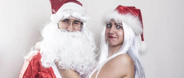 Female and male Santa Claus hugging with funny expressions lette — Stock Photo, Image