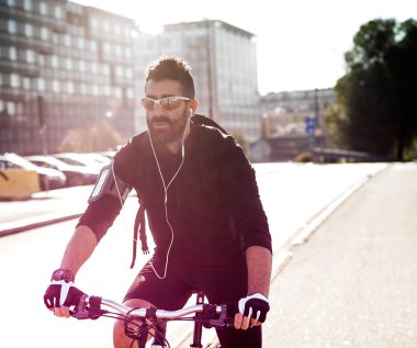 Güneş gözlüğü takıyor şehirde yakışıklı bisikletçi portresi