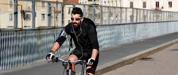 Sportsman riding bicycle in the city and wearing sunglasses lett — Stock Photo, Image