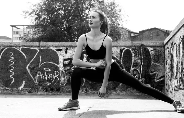 Ritratto donna atletica facendo stretching in città monocromatico — Foto Stock