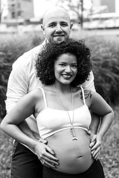 Pareja feliz en la ciudad esperando bebé blanco y negro — Foto de Stock