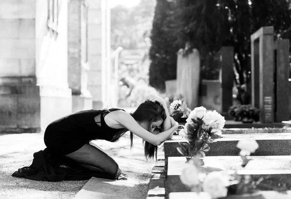 Afflicted woman in grief in front of grave monochrome — Stock Photo, Image