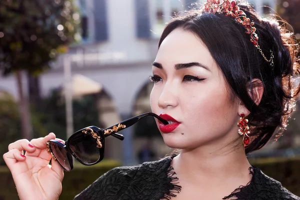 Wanita cantik potret mengenakan tiara dan memegang kacamata hitam — Stok Foto