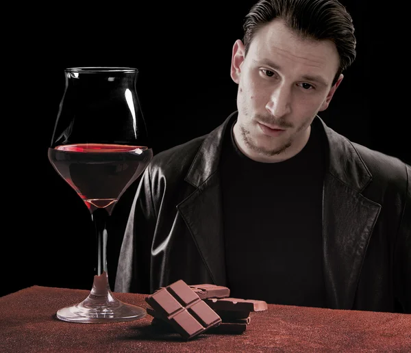 Verre à vin rouge avec chocolat et beau portrait d'homme — Photo